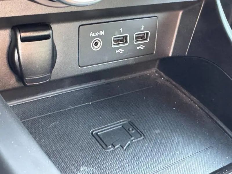 Gros plan sur la console centrale noire du Renault Arkana 1.6 E-Tech avec prises USB et entrée Aux-In visibles.