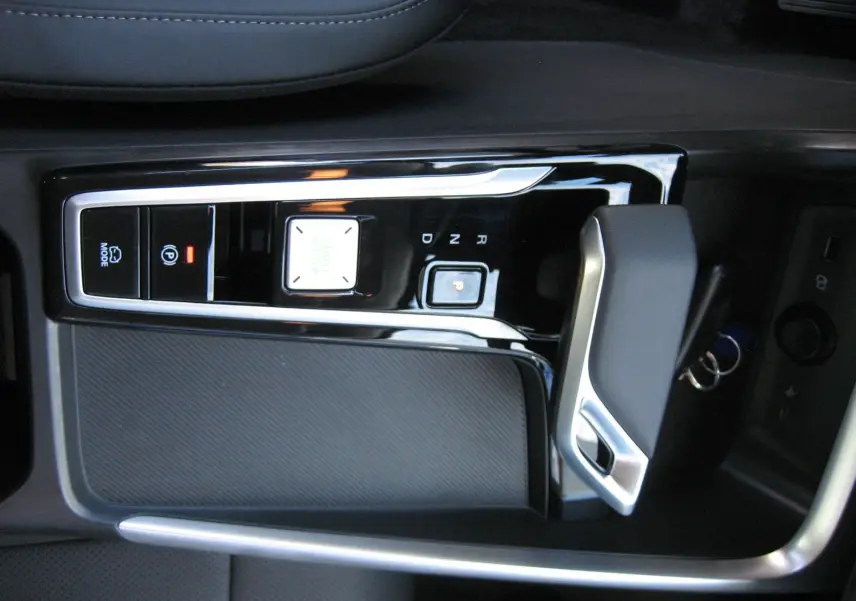 Vue rapprochée de la console centrale noire brillante avec levier de vitesse automatique du MG ZS blanc hybride 2026.