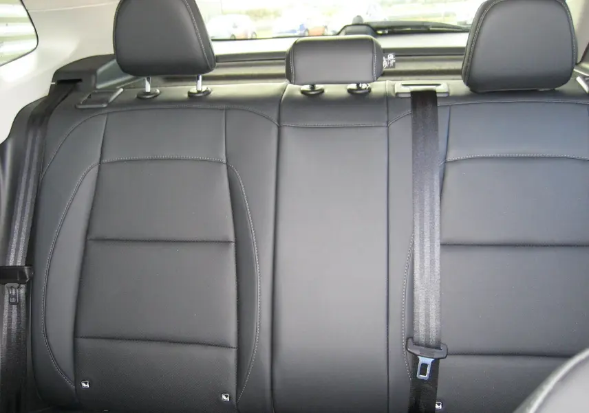 Vue rapprochée des sièges arrière en cuir noir du MG ZS 1.5 HYBRID+197 LUXURY 2026, avec appuie-têtes et ceinture de sécurité.
