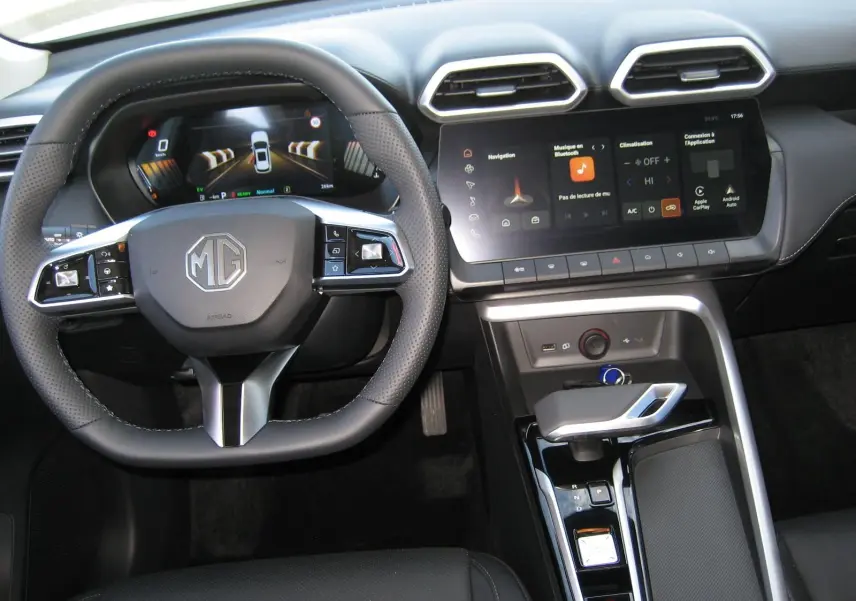 Vue intérieure centrée sur le volant et la console centrale du MG ZS blanc, avec écran tactile et commandes modernes.