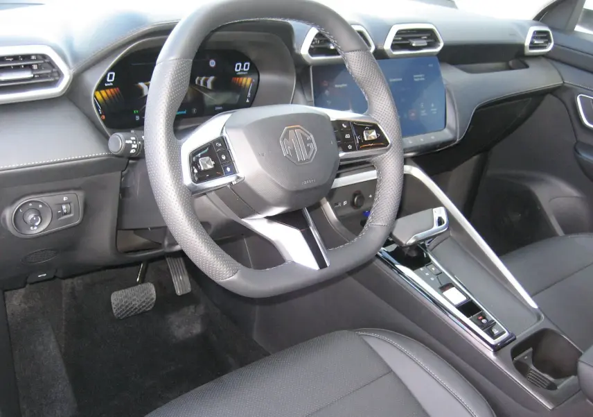 Vue intérieure centrée sur le volant et la console centrale du MG ZS 1.5 HYBRID+197 LUXURY avec sellerie noire et écran tactile.