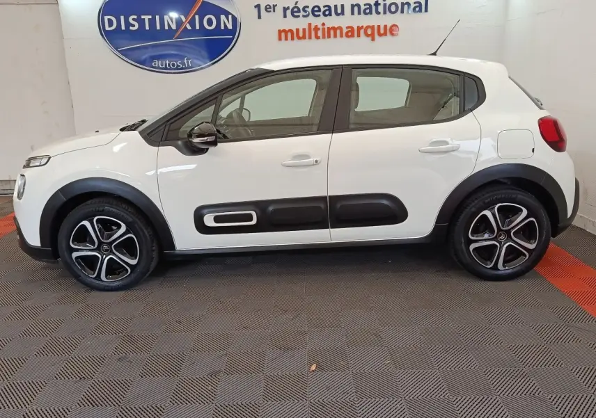 Profil droit d'une Citroën C3 blanche de 2022 avec protections latérales noires et jantes alliage bicolores.