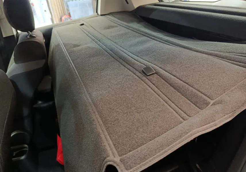 Vue intérieure du coffre de la Citroën C3 2022 avec cache-bagages gris étendu sur les sièges arrière.