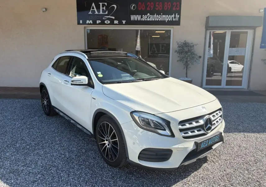 Mercedes GLA 220d blanc en 3/4 avant droit, avec jantes noires et toit ouvrant panoramique visible.