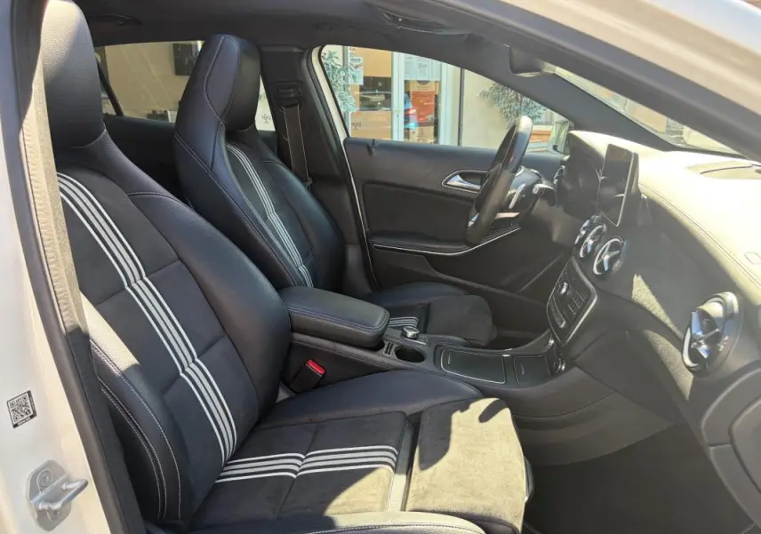 Intérieur de la Mercedes GLA 220d 2017 vue côté gauche, sièges noirs avec bandes blanches distinctives.