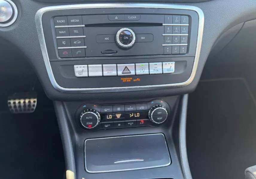 Vue rapprochée du tableau de bord central et de la console de la Mercedes GLA 220d White Art Edition 2017, avec commandes audio et climatisation.