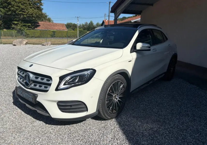 Mercedes GLA 220d blanc vue 3/4 avant droit, jantes noires et toit panoramique sous un abri extérieur.