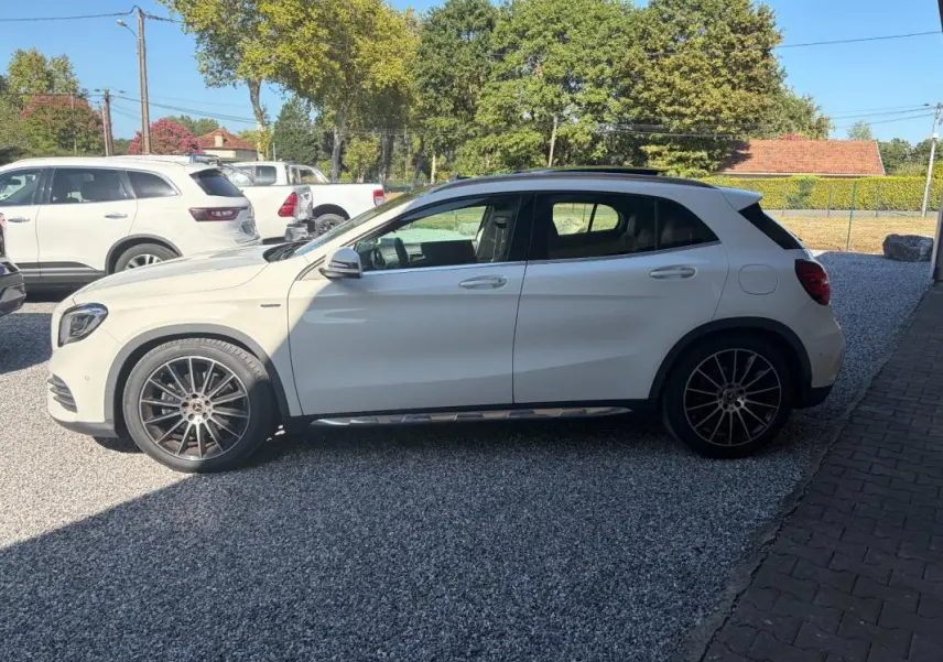 Mercedes GLA 220d blanc vue de profil côté gauche, avec jantes alliage distinctives et toit noir contrastant.