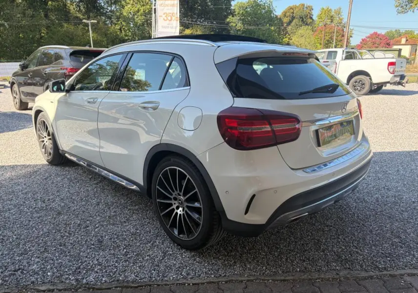 Mercedes GLA 220d blanc en vue 3/4 arrière droit, avec jantes noires et toit panoramique noir.
