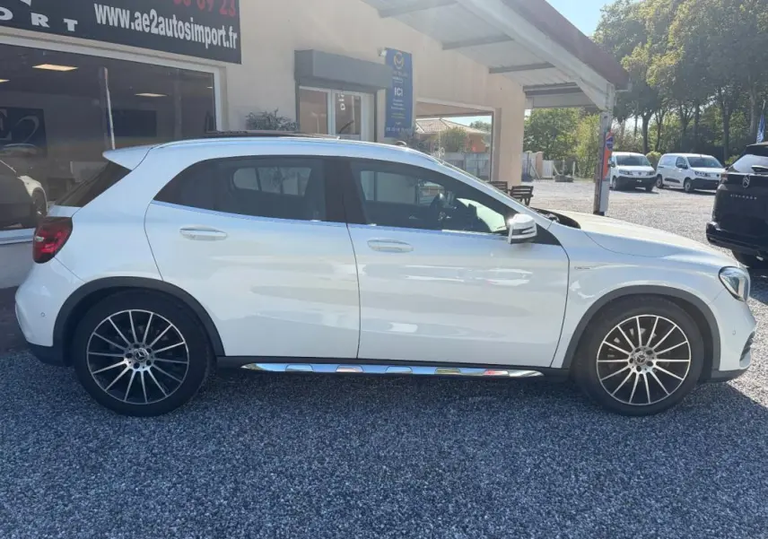 Vue de profil côté gauche d'un Mercedes GLA 220d blanc avec jantes alliage et bas de caisse chromé, stationné en extérieur.