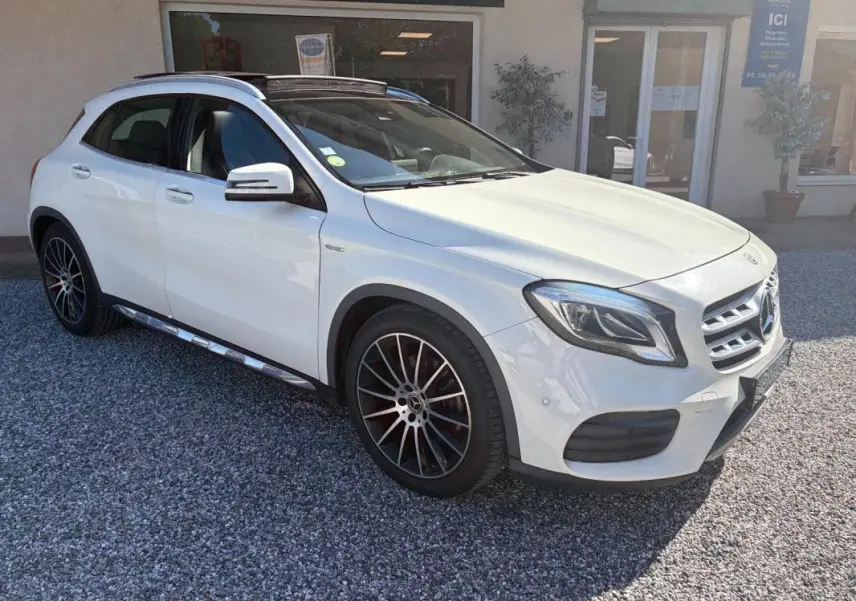 Mercedes GLA 220d blanc en 3/4 avant droit, avec jantes alliage noir et toit ouvrant panoramique visible.