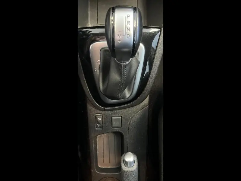 Gros plan sur la commande de boîte automatique et les boutons de fonction au centre de la console d'une Renault Clio Estate blanche.