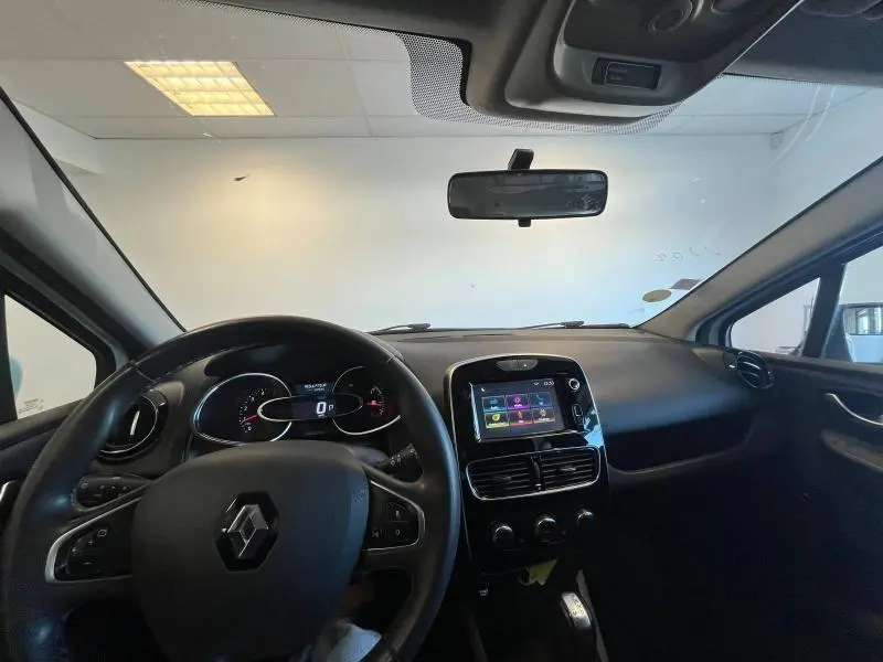 Vue intérieure avant de la Renault Clio Estate 2019, tableau de bord noir avec écran tactile et volant cuir.