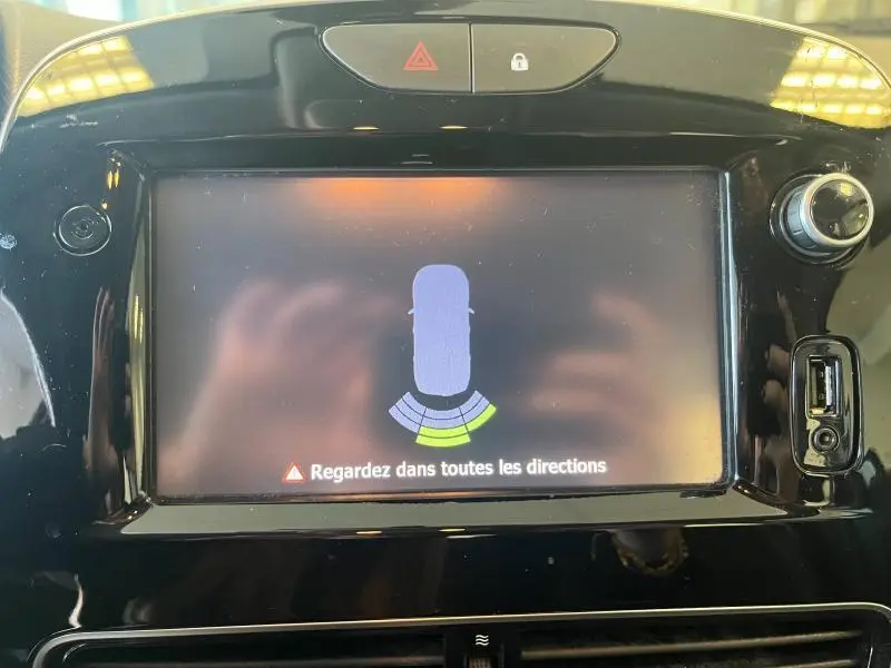 Écran tactile central du tableau de bord de la Renault Clio Estate blanc glacier montrant le radar de recul actif.