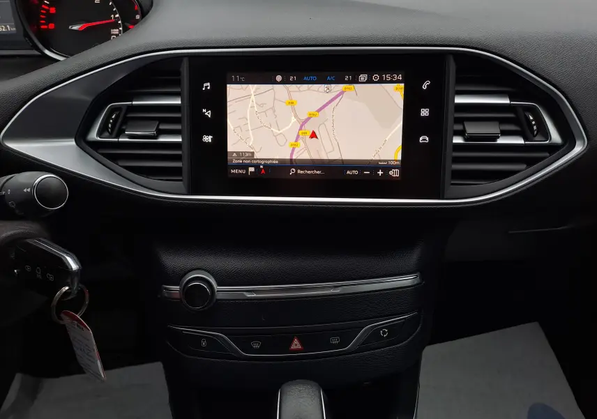 Vue rapprochée du tableau de bord noir de la Peugeot 308 2019 avec écran tactile affichant la navigation GPS.