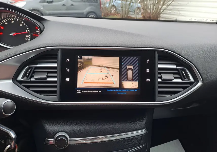 Écran central de Peugeot 308 gris 2019 montrant la caméra de recul et l'affichage 360° du véhicule en stationnement.