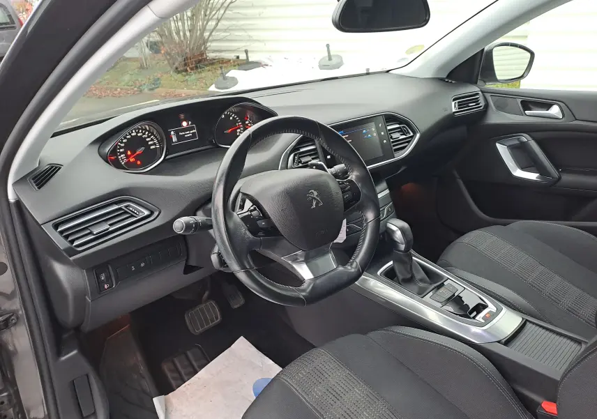 Intérieur noir de la Peugeot 308 Diesel 2019, vue côté conducteur avec tableau de bord et volant cuir.