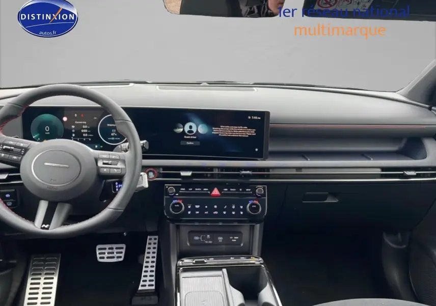 Vue intérieure frontale du tableau de bord du Hyundai Tucson gris, avec écran tactile large et volant sport N Line en cuir.