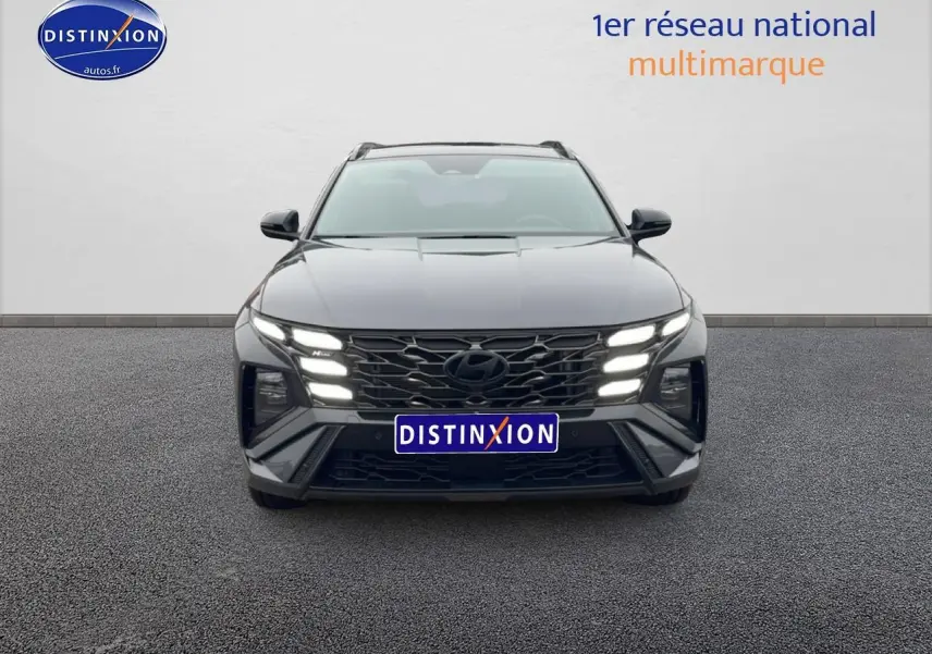 Vue frontale du Hyundai Tucson gris écotronique avec calandre n-line et feux LED allumés sur fond neutre.