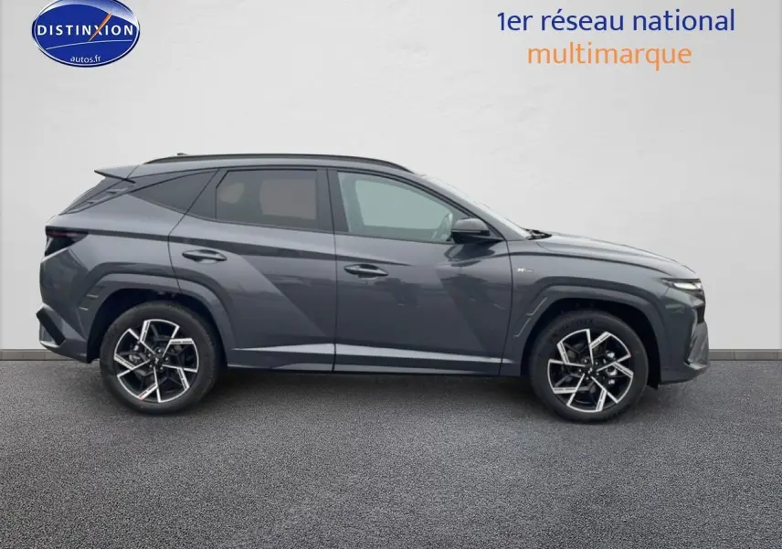 Vue de profil côté gauche du Hyundai Tucson 2025 gris ecotronique avec jantes alliage 19 pouces design N-Line.