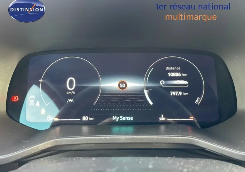 Tableau de bord numérique de Renault Clio rouge, affichant la vitesse à 0 km/h et l'autonomie restante.