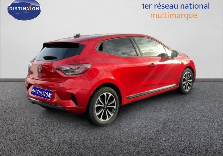 Vue 3/4 arrière droite d'une Renault Clio 2025 rouge Désir Métal avec jantes alliage et vitres teintées.