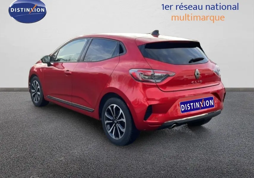 Vue 3/4 arrière droite d'une Renault Clio rouge Désir Métal avec jantes alliage et feux LED distinctifs.