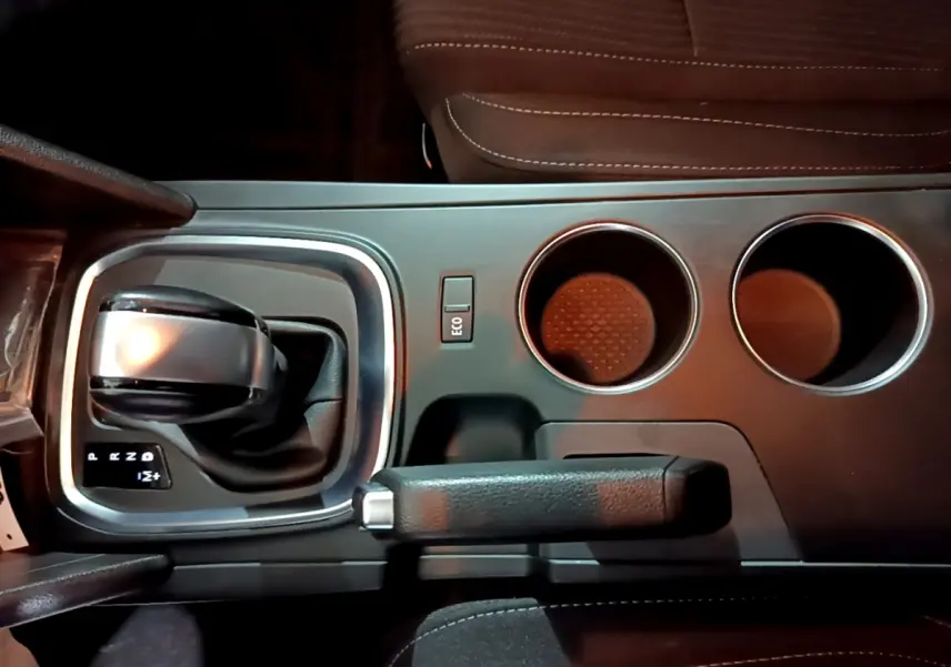 Vue plongeante sur la console centrale noire de la Renault Mégane Business Blue dCi 115 EDC avec levier de boîte auto et porte-gobelets.