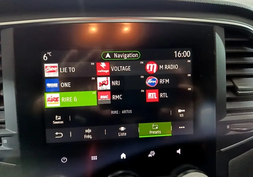 Écran tactile central de la Renault Mégane Business gris clair affichant les stations radio et la navigation à 16h.