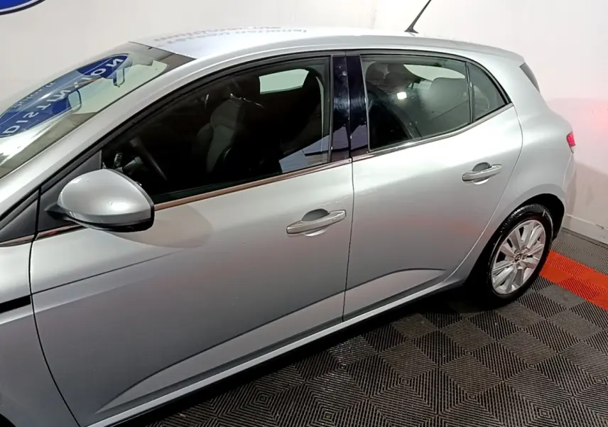 Vue latérale droite d'une Renault Mégane Business Blue dCi 115 EDC gris clair, avec poignées et rétroviseur assortis.