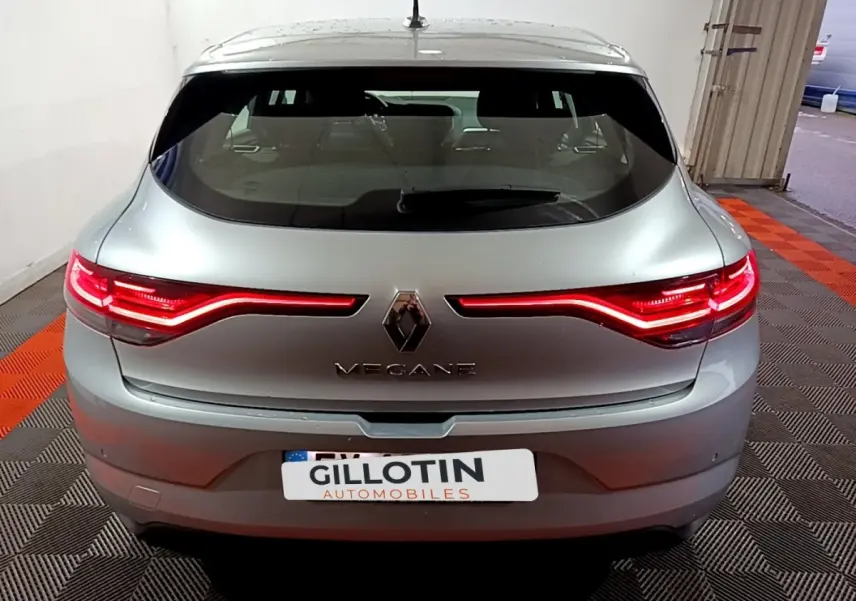 Vue arrière d'une Renault Mégane gris clair avec feux LED allumés dans un garage intérieur.
