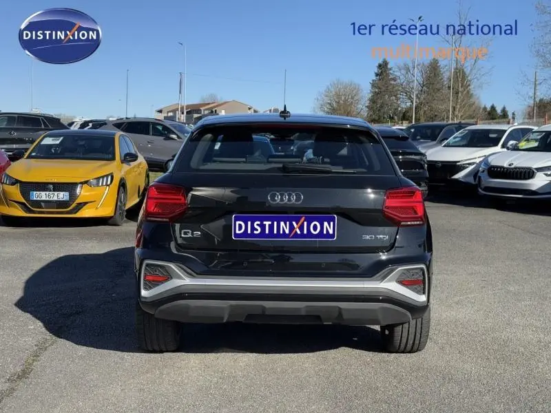 Vue arrière d'un Audi Q2 30 TDI S line noir Mythic métallisé, avec feux LED et bouclier gris contrastant.