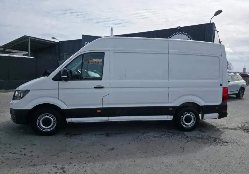 Volkswagen Crafter Fourgon blanc vu de profil côté gauche, avec protections noires sur bas de caisse.
