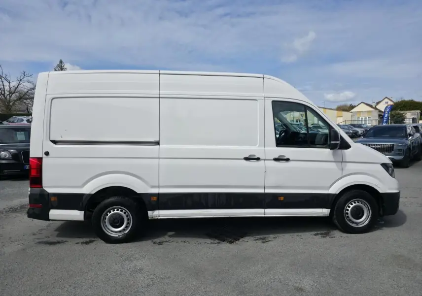Volkswagen Crafter Fourgon blanc en profil droit, avec portes latérales coulissantes et jantes acier argentées.