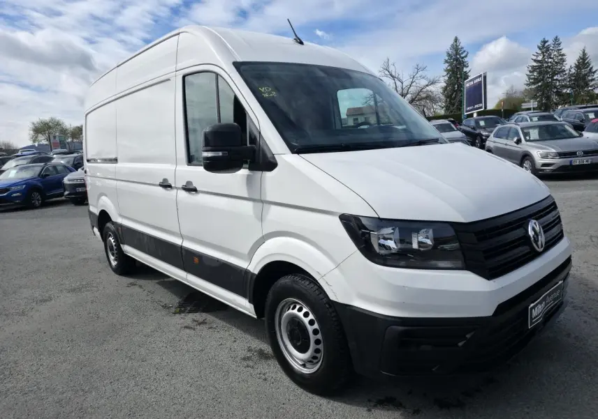 Volkswagen Crafter fourgon blanc vu en 3/4 avant droit avec protections noires et jantes acier argentées.