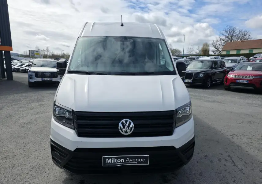 Vue frontale d'un Volkswagen Crafter fourgon blanc avec calandre noire et logo VW bien visible.
