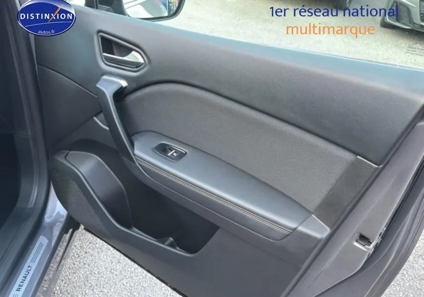 Vue intérieure côté gauche de la porte avant grise du Renault Symbioz 2025 avec poignée et bouton de lève-vitre.