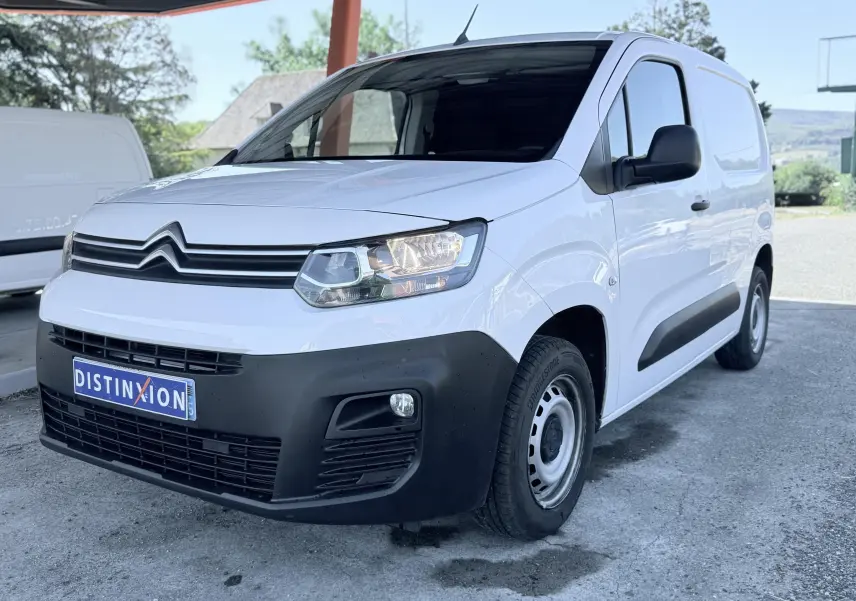 Citroën Berlingo blanc en 3/4 avant droit, avec pare-chocs noir mat et jantes acier simples.