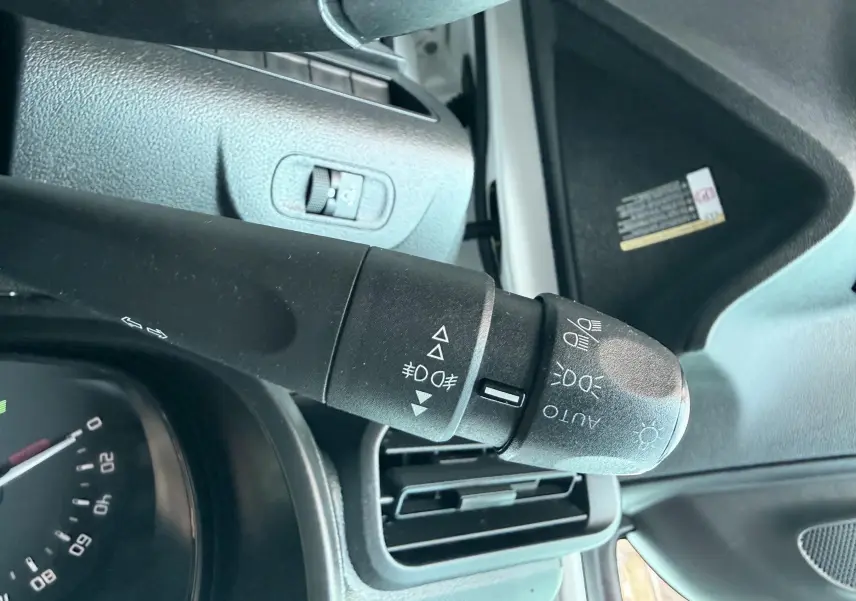 Gros plan sur la commande des feux du Citroën Berlingo 2019, intérieur noir avec détails de la planche de bord.