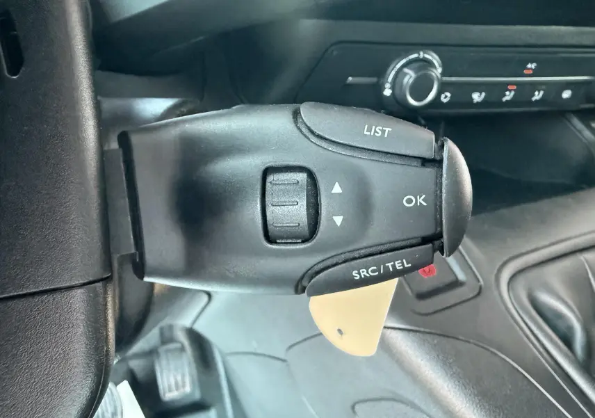 Gros plan sur la commande au volant du Citroën Berlingo blanc 2019, avec boutons LIST, OK et SRC/TEL visibles.
