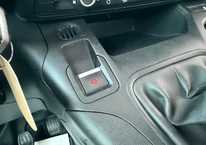 Gros plan sur la console centrale noire du Citroën Berlingo 2019, avec frein à main électrique et levier de vitesse manuel.