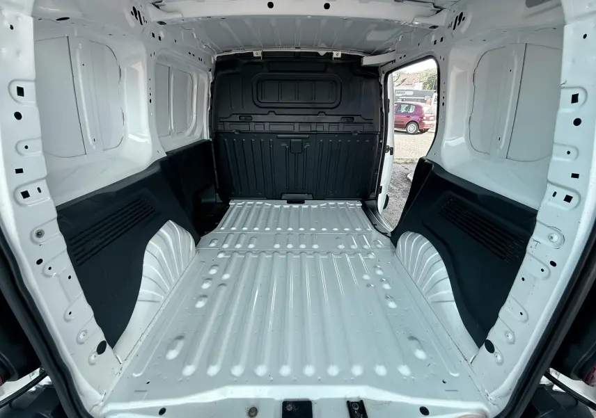 Vue intérieure arrière du Citroën Berlingo blanc 2019, montrant l’espace de chargement vide avec parois métalliques.