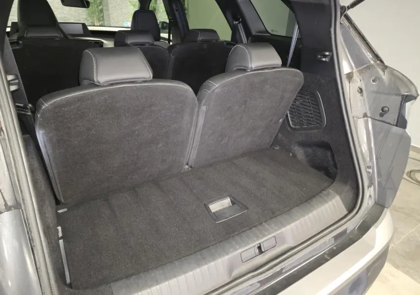 Vue arrière du coffre ouvert du Peugeot 5008 gris, montrant la banquette arrière en position relevée.