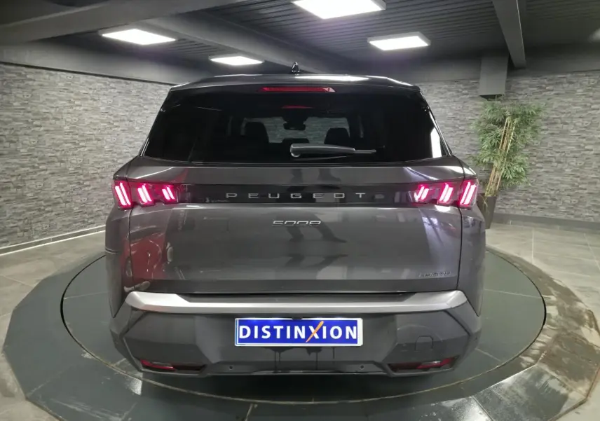 Vue arrière d'un Peugeot 5008 gris métallisé avec feux arrière LED en forme de griffes et bandeau noir laqué.