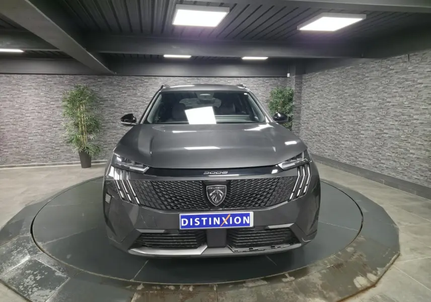 Vue avant centrée du Peugeot 5008 gris métallisé avec calandre noire et feux LED à griffes distinctifs.