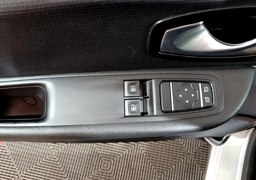 Gros plan sur la commande des vitres et rétroviseurs côté conducteur d'une Renault Clio Business gris clair 2018.