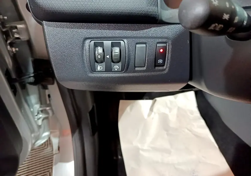 Vue rapprochée des commandes de réglage des phares et du système start-stop sur la Renault Clio Business gris clair 2018.