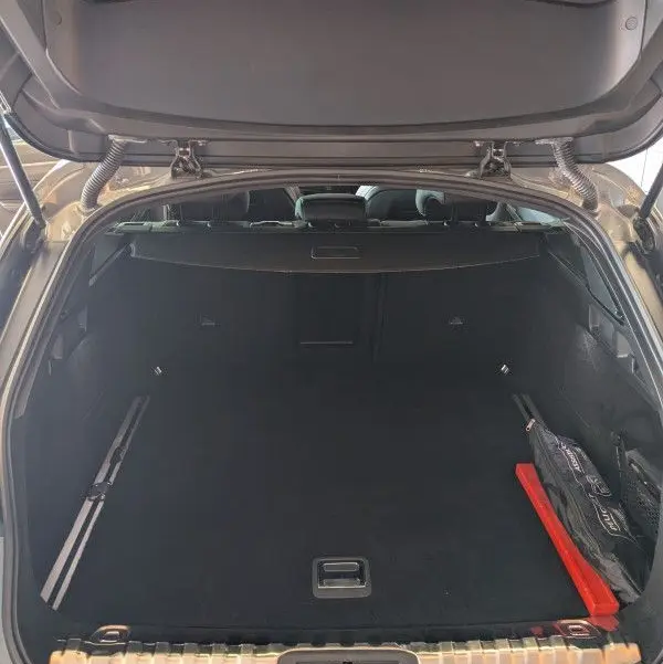 Coffre ouvert du Peugeot 508 SW gris Selenium, vue arrière montrant un espace de chargement spacieux et bien fini.