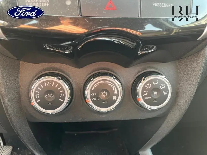 Gros plan sur les commandes de climatisation d'une Citroën C4 Aircross brun Mangaro, avec réglages automatiques et ventilation.