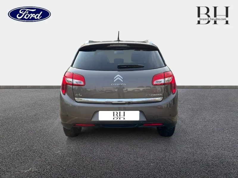 Vue arrière d'une Citroën C4 Aircross 2016 brun Mangaro avec feux rouges et lunette arrière surteintée.